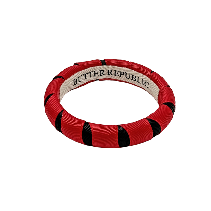 red and black Butter Republic bracelet with a brand label on the interior of the bracelet