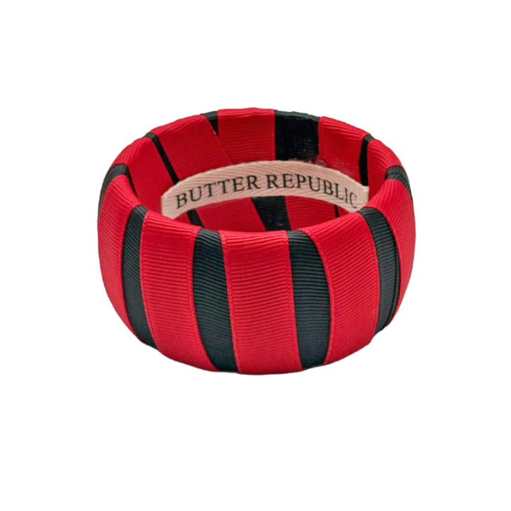 red and black wide Butter Republic bracelet with a brand label on the interior of the bracelet