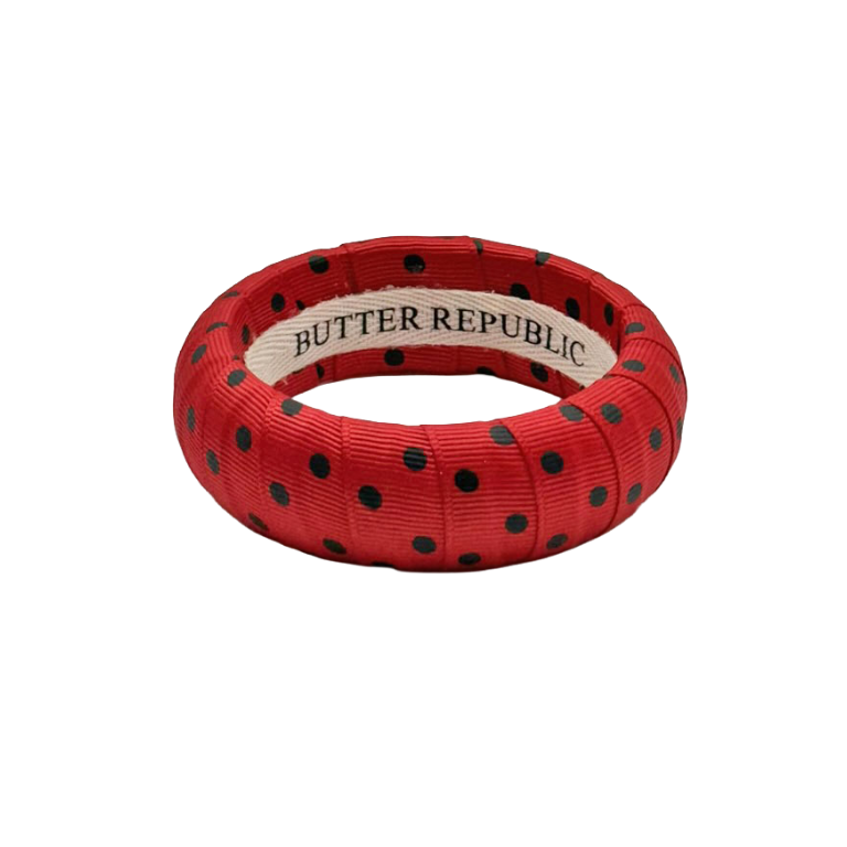 red and black polka dot Butter Republic bracelet with a brand label on the interior of the bracelet