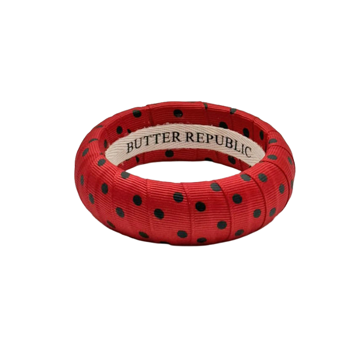 red and black polka dot Butter Republic bracelet with a brand label on the interior of the bracelet