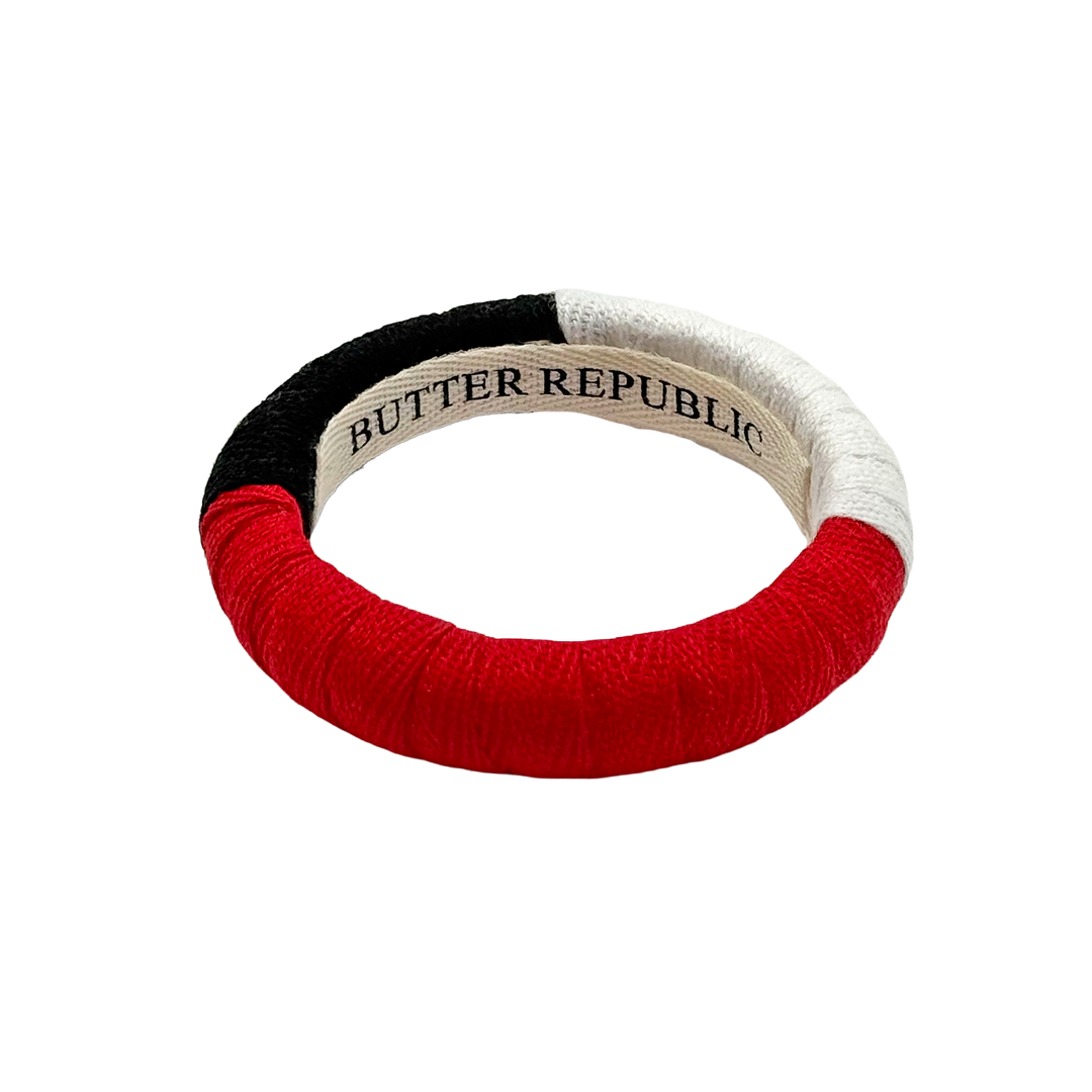 red, black, and white color-block Butter Republic bracelet with a logo brand label on the interior of the bracelet