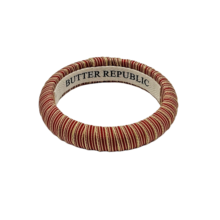 red and cream pinstripe Butter Republic bracelet with a logo brand label on the interior of the bracelet