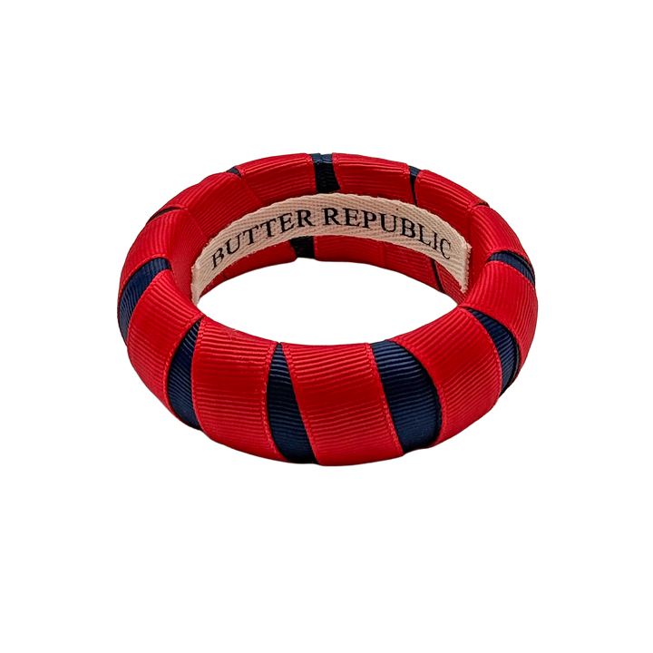 red and navy blue Butter Republic bracelet with a logo brand label on the interior of the bracelet