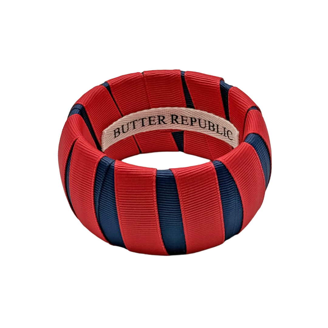 red and navy blue wide Butter Republic bracelet with a logo brand label on the interior of the bracelet