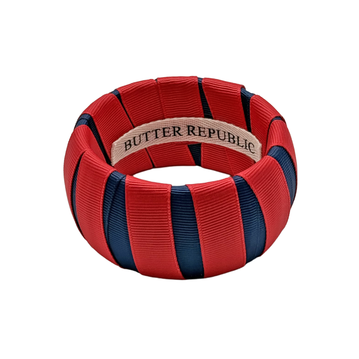 red and navy blue wide Butter Republic bracelet with a logo brand label on the interior of the bracelet