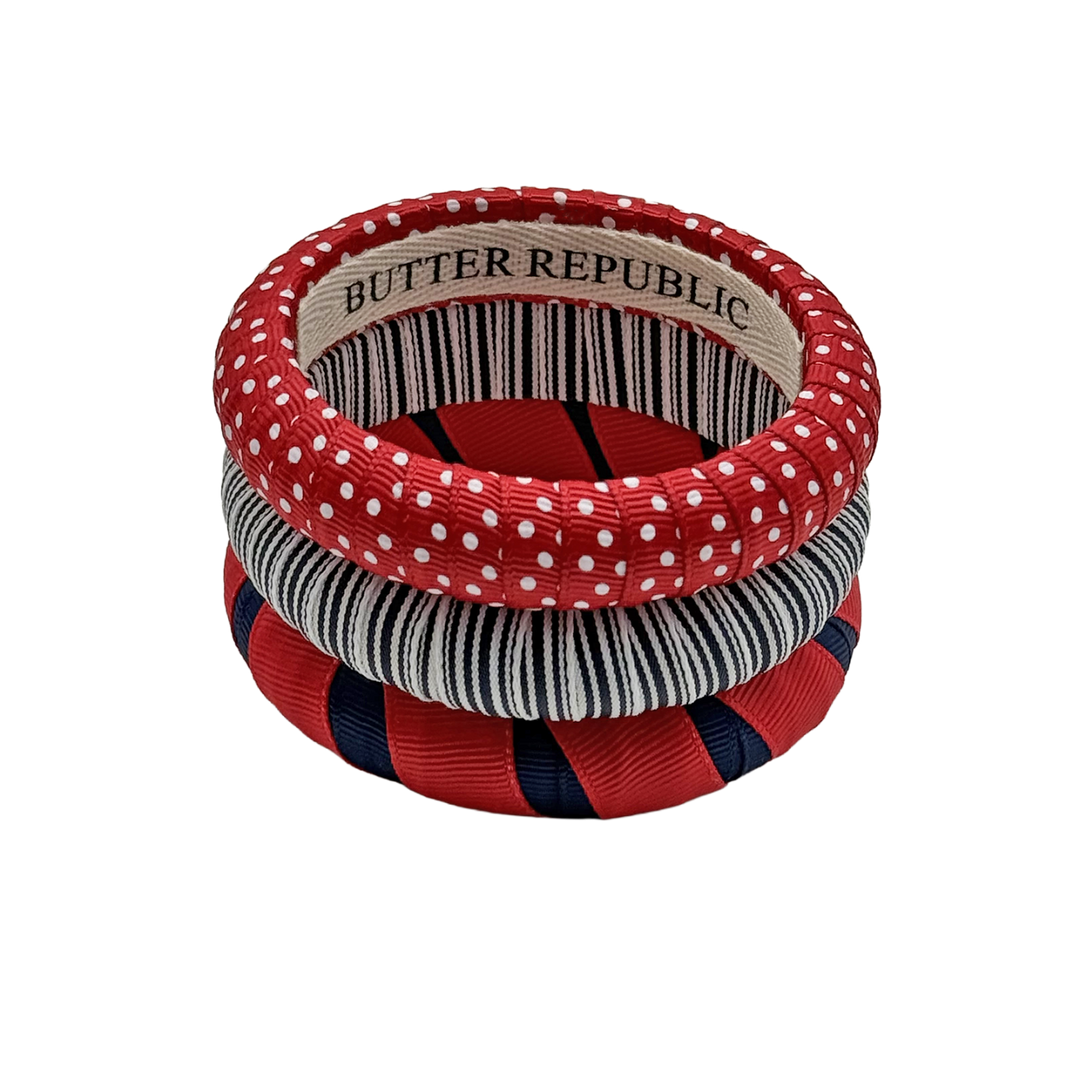 set of three navy blue and red Butter Republic bracelets with a logo brand label on the interior of one the bracelets