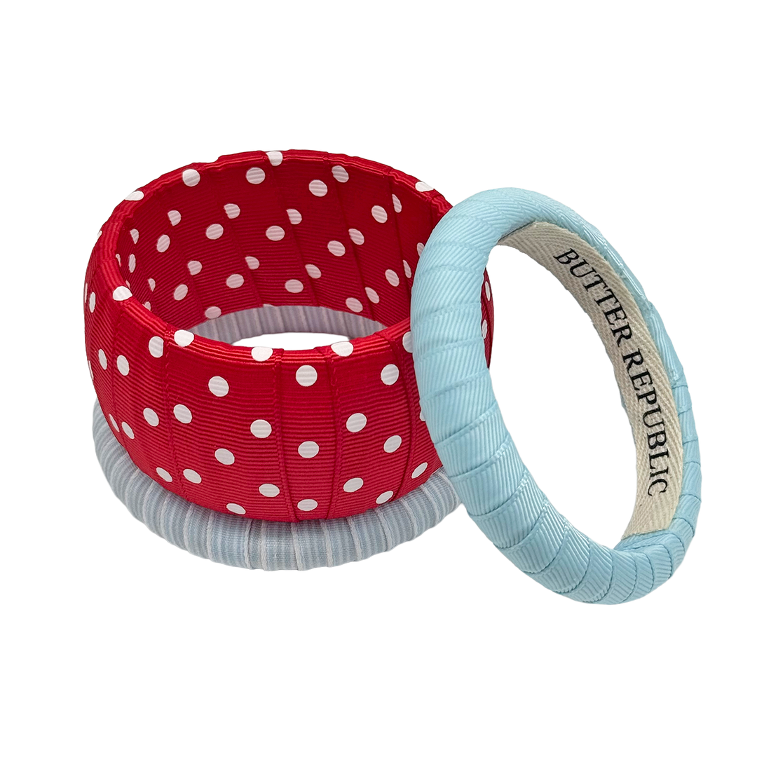 Red, white, and powder blue assortment of Butter Republic bracelets with brand label on the interior