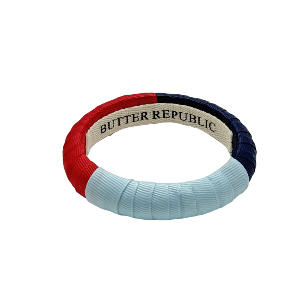 red, powder blue, and navy blue color-block Butter Republic bracelet with logo branding on the interior of the bracelet