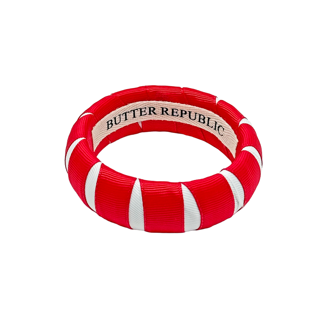 red and white Butter Republic bracelet with a logo brand label on the interior of the bracelet