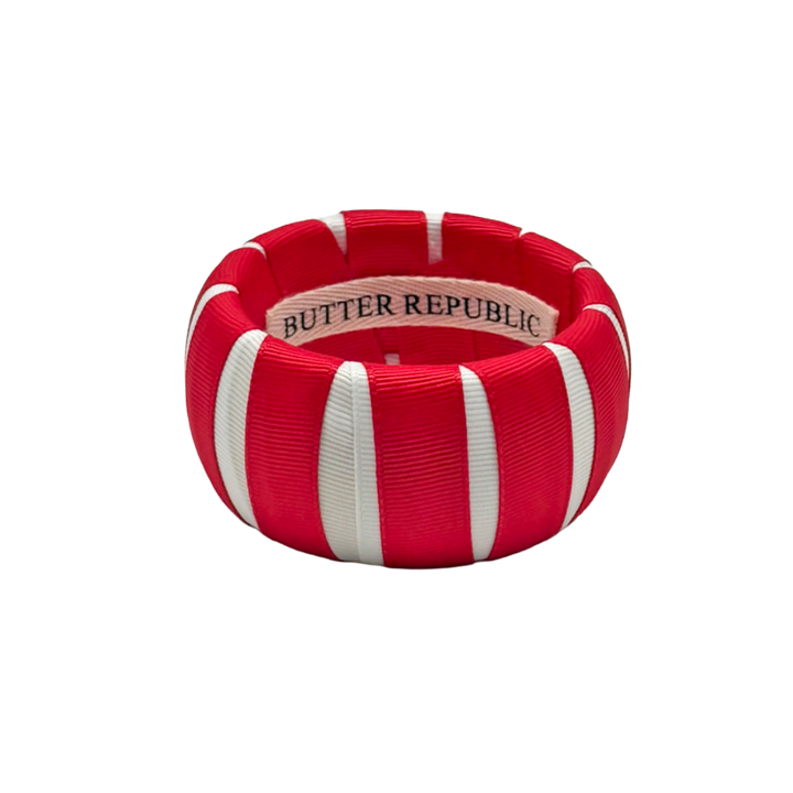 red and white Butter Republic bracelet with a logo brand label on the interior of the bracelet