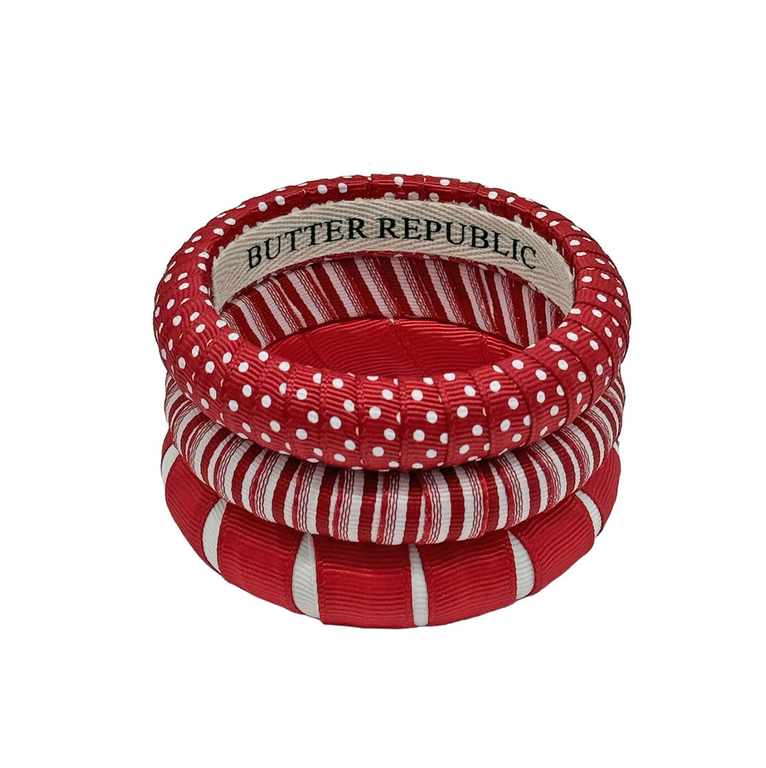set of three red and white Butter Republic bracelets with a logo brand label visible on the interior of one of the bracelets