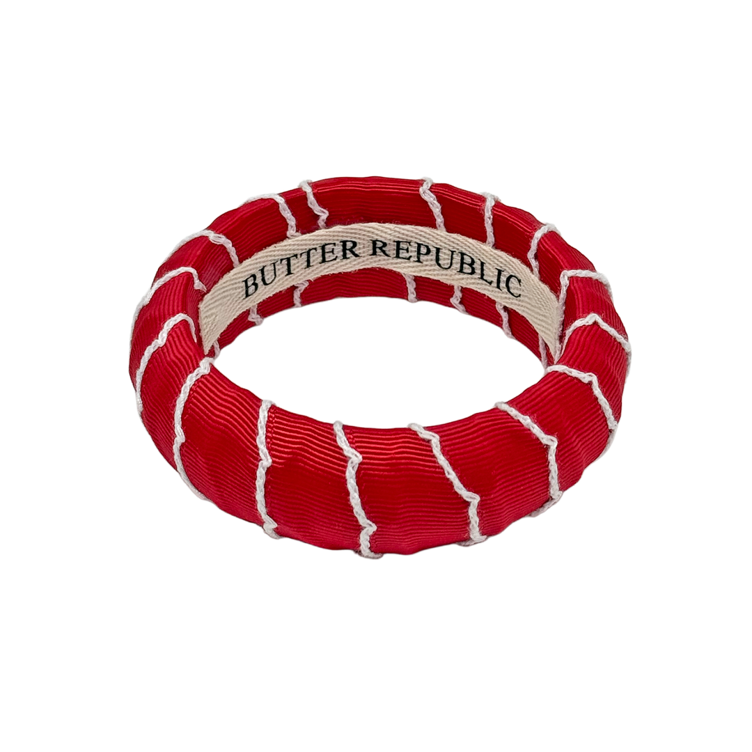 Red and white bracelet with Butter Republic branding label on the interior
