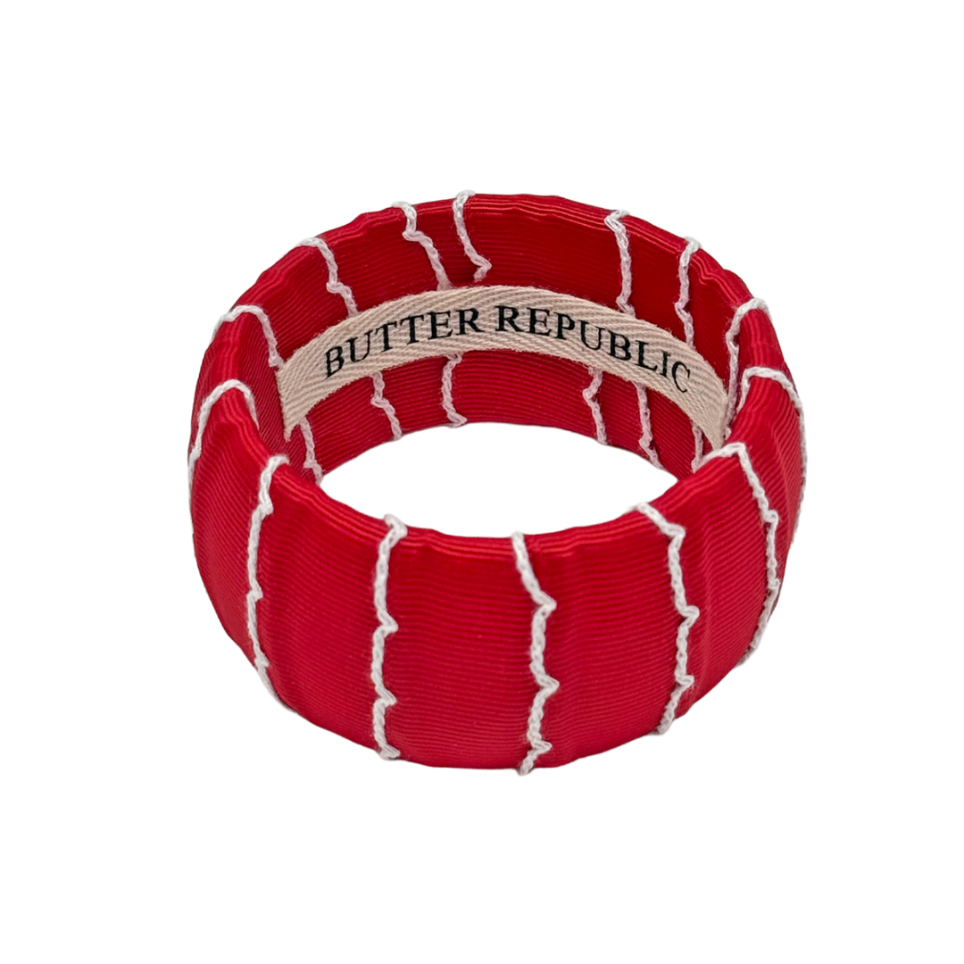 Red and white moonstitch ribbon bracelet with Butter Republic branding on the interior