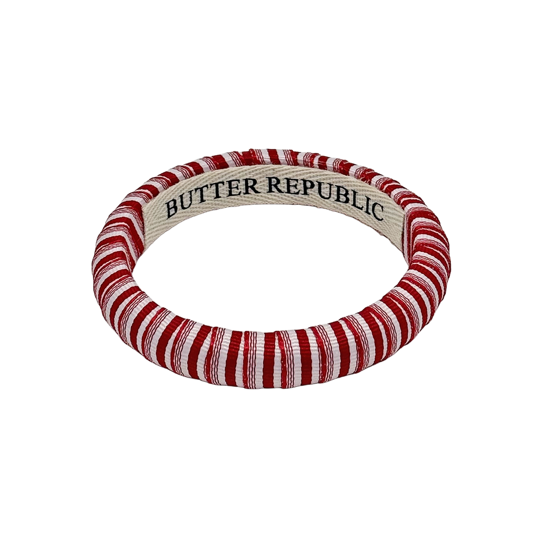 red and white narrow pinstripe Butter Republic bracelet with a logo brand label on the interior of the bracelet