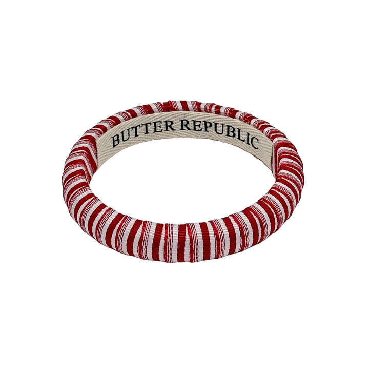 red and white narrow pinstripe Butter Republic bracelet with a logo brand label on the interior of the bracelet