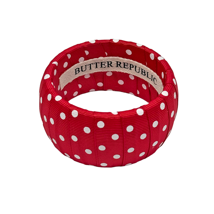 Red and white polka dot bracelet with Butter Republic branding on the interior