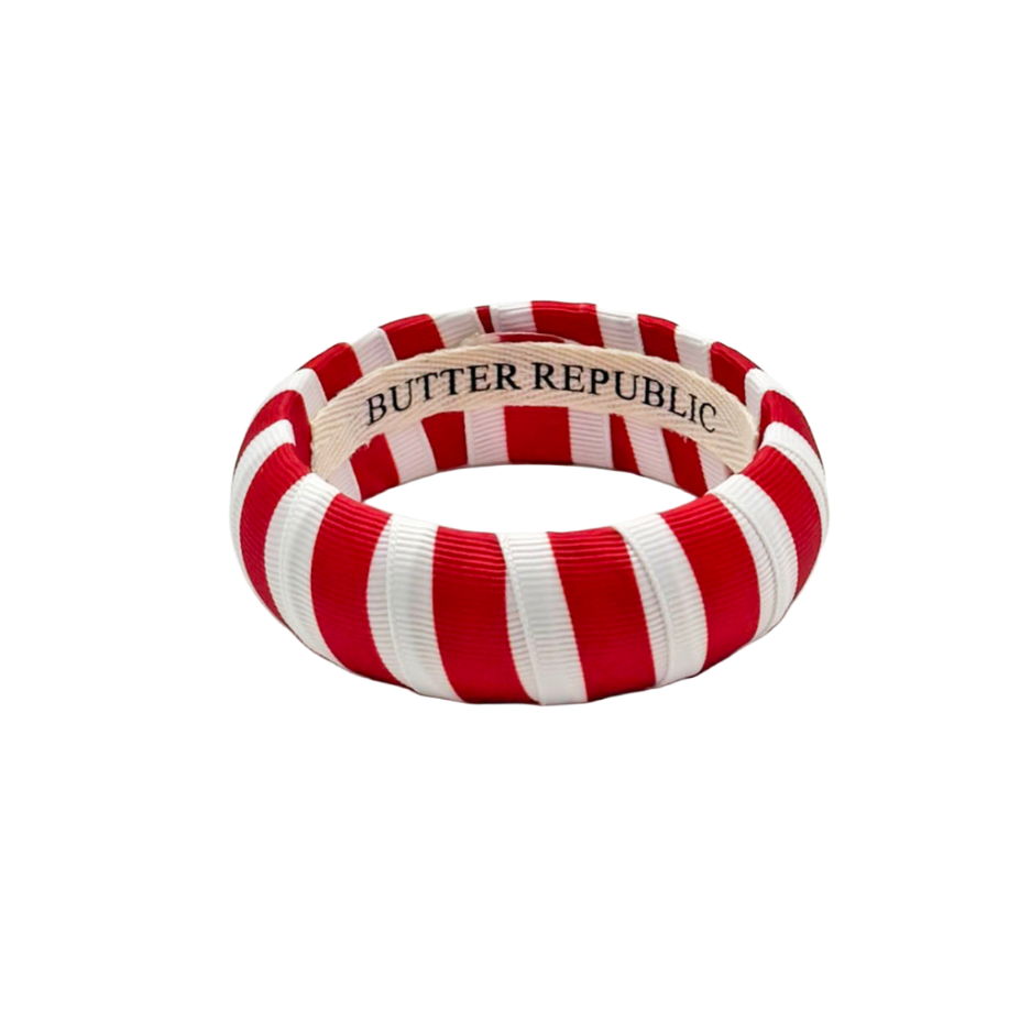 red and white striped Butter Republic bracelet with a logo brand label on the interior of the bracelet