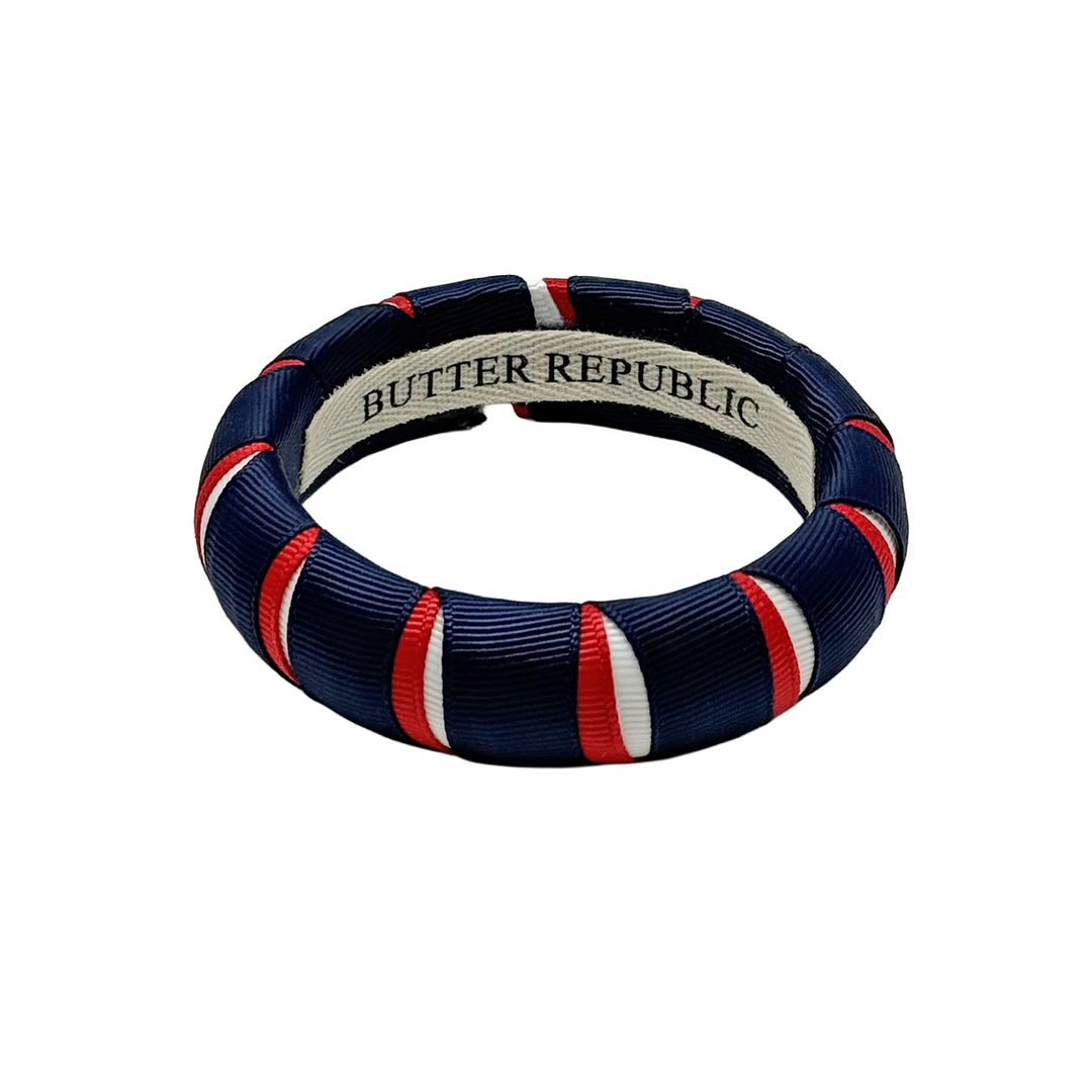 red, white, and navy blue Butter Republic bracelet with a logo brand label on the interior of the bracelet