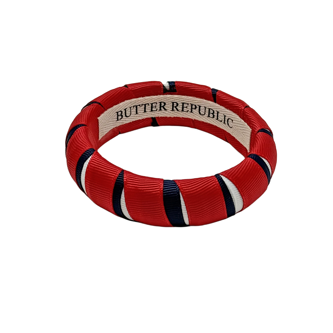 red, white, and navy blue Butter Republic bracelet with a logo brand label on the interior of the bracelet