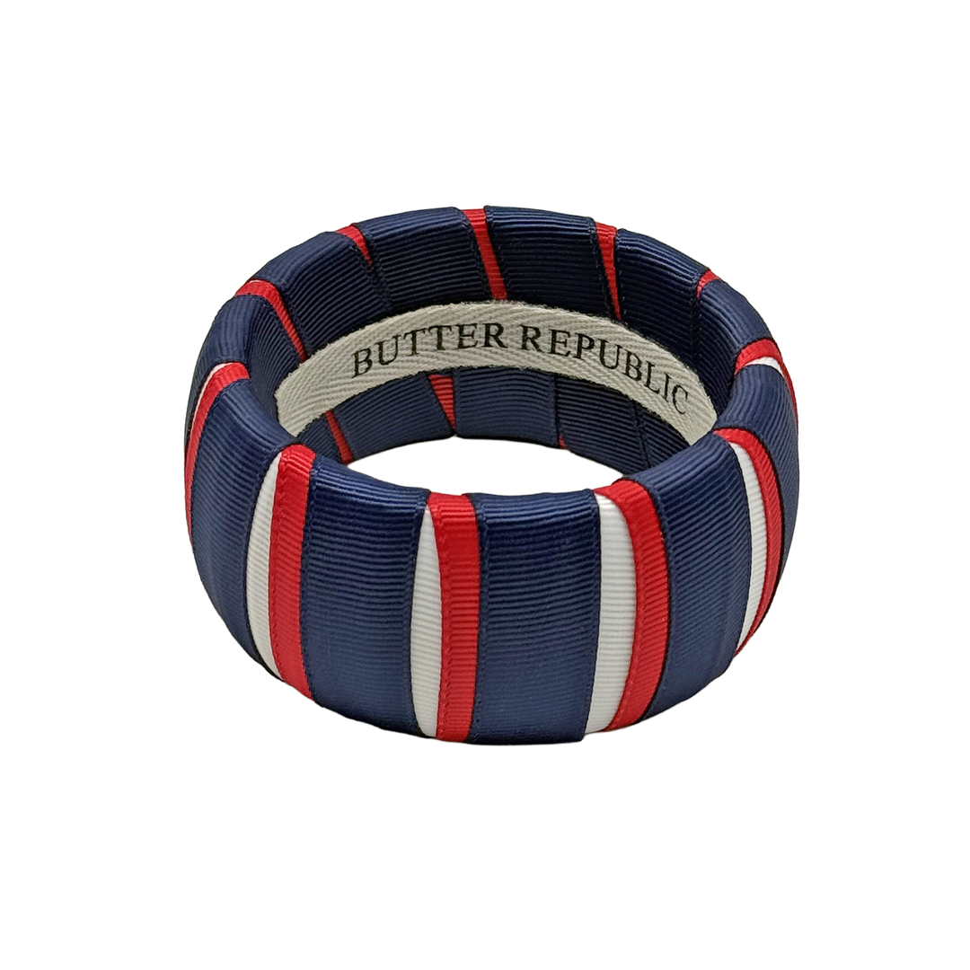 red, white, and navy blue Butter Republic bracelet with a logo brand label on the interior of the bracelet