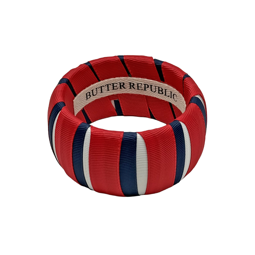 red, white, and navy blue wide Butter Republic bracelet with a logo brand label on the interior of the bracelet