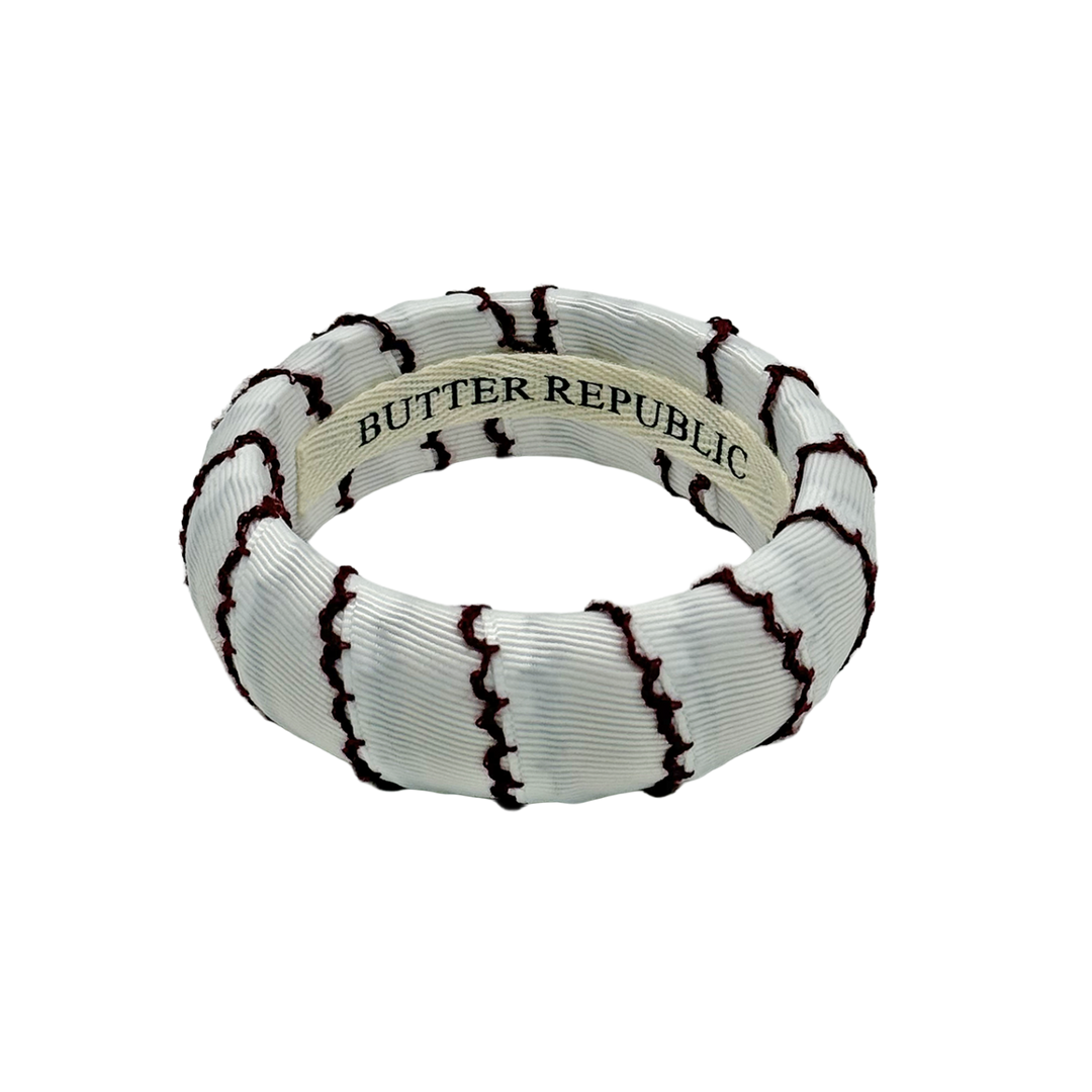 white Butter Republic bracelet with maroon-edged thread with logo brand label visible on the interior of the bracelet