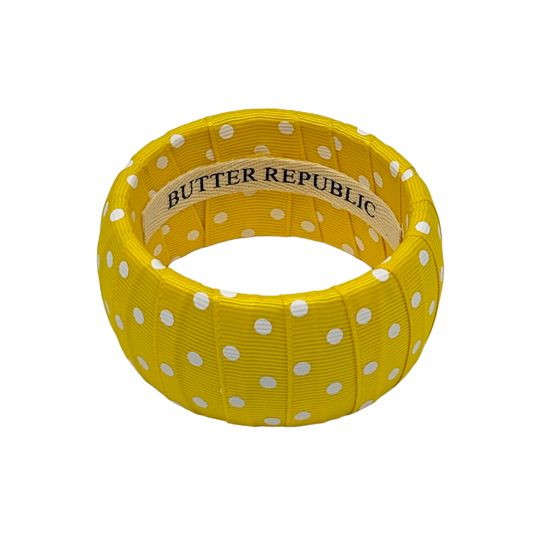 Yellow and white polka dot bracelet with Butter Republic brand label on the interior